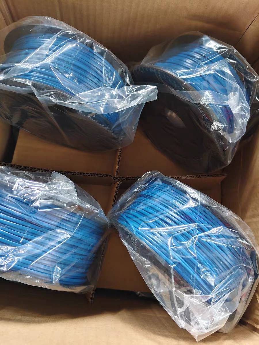 Four blue LHD thermal sensor cable spools sealed in clear polybags and packed into a corrugated shipping carton, top-down view of the carton interior