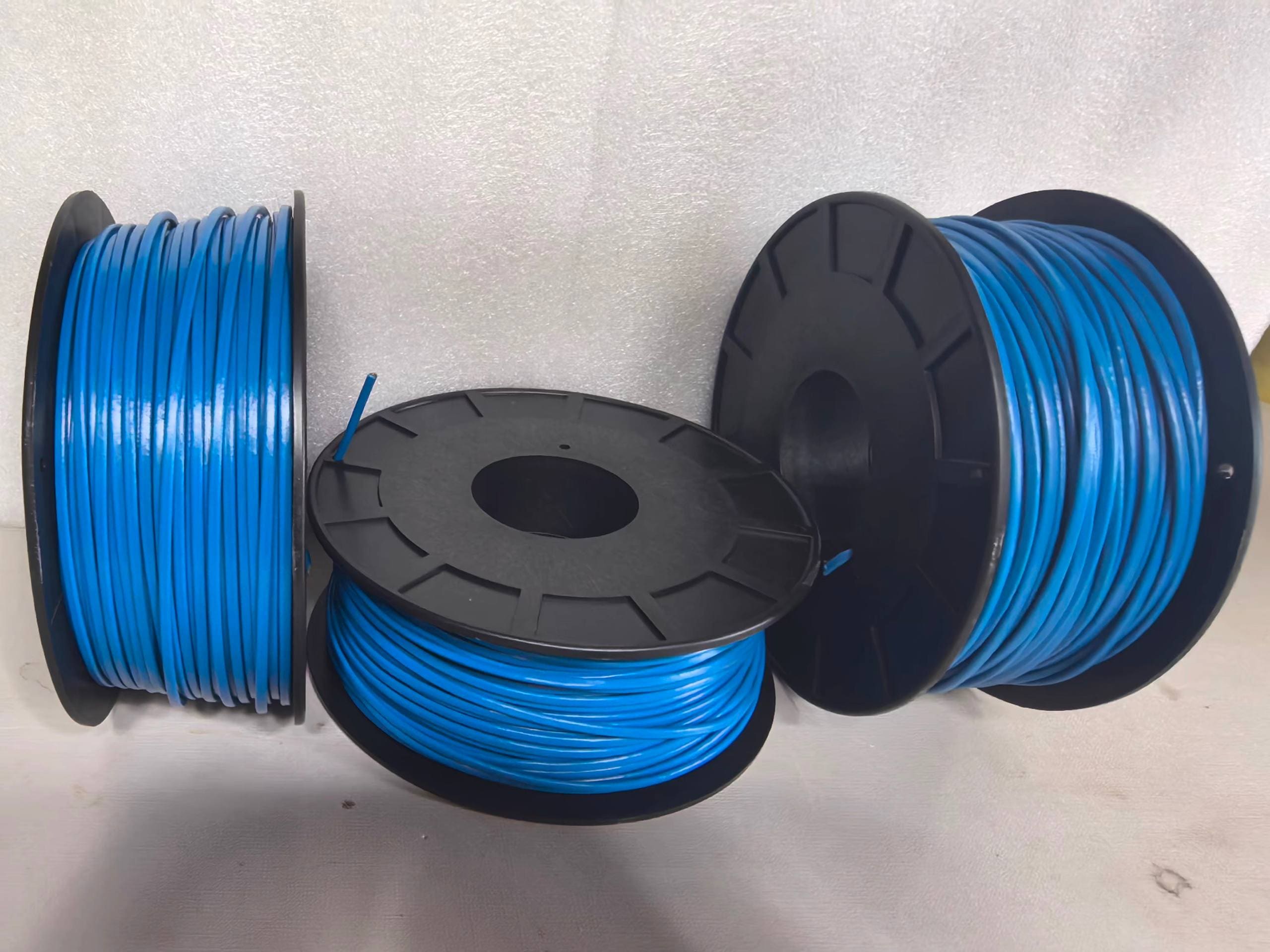 Three blue LHD thermal sensor cable spools on black plastic flanged reels, one laid flat in front showing the spool face, photographed against a plain studio background